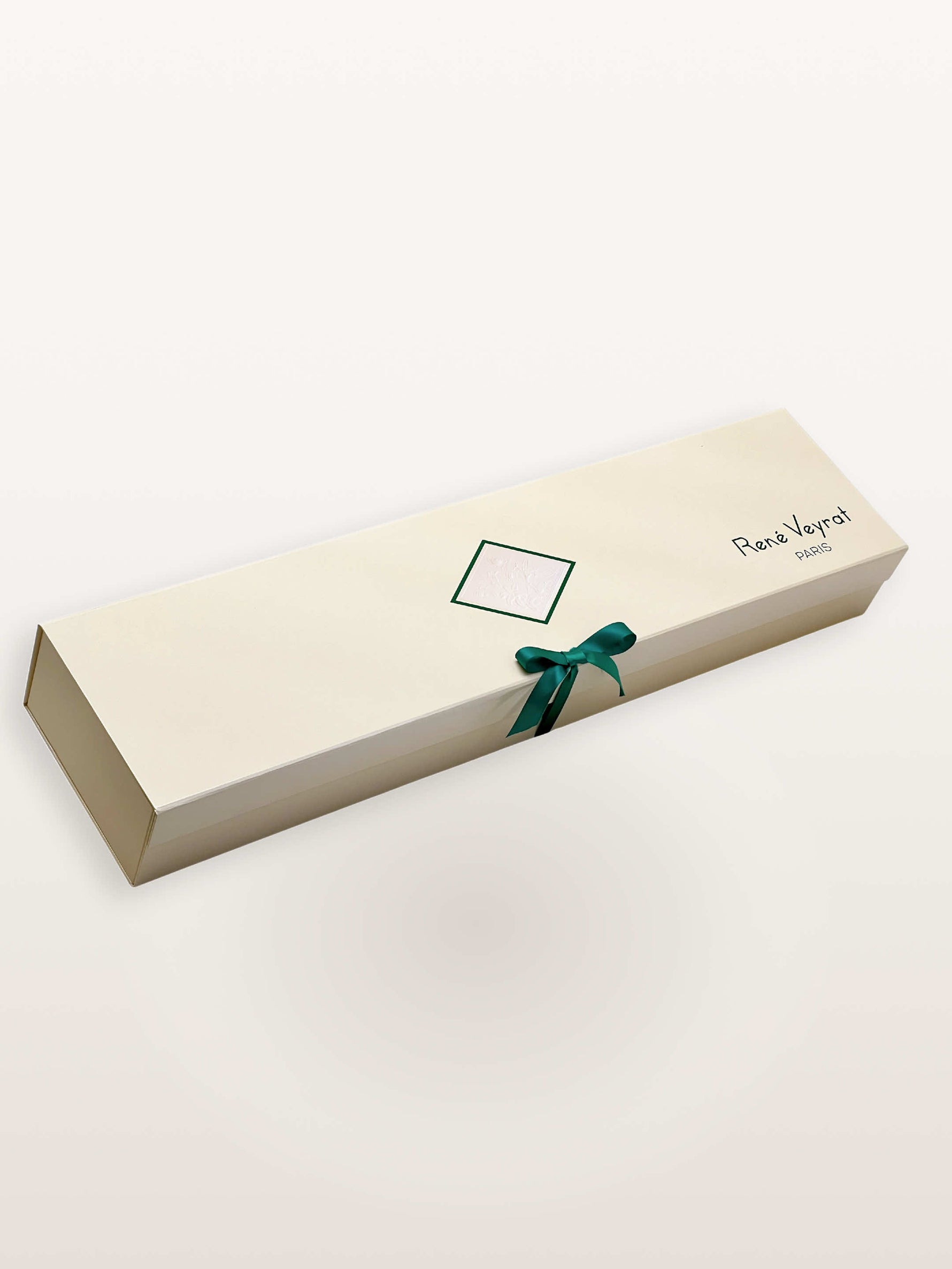 Coffret Chantilly ivoire fermé, ruban vert sapin noué en nœud, cachet gaufré et signature René Veyrat Paris