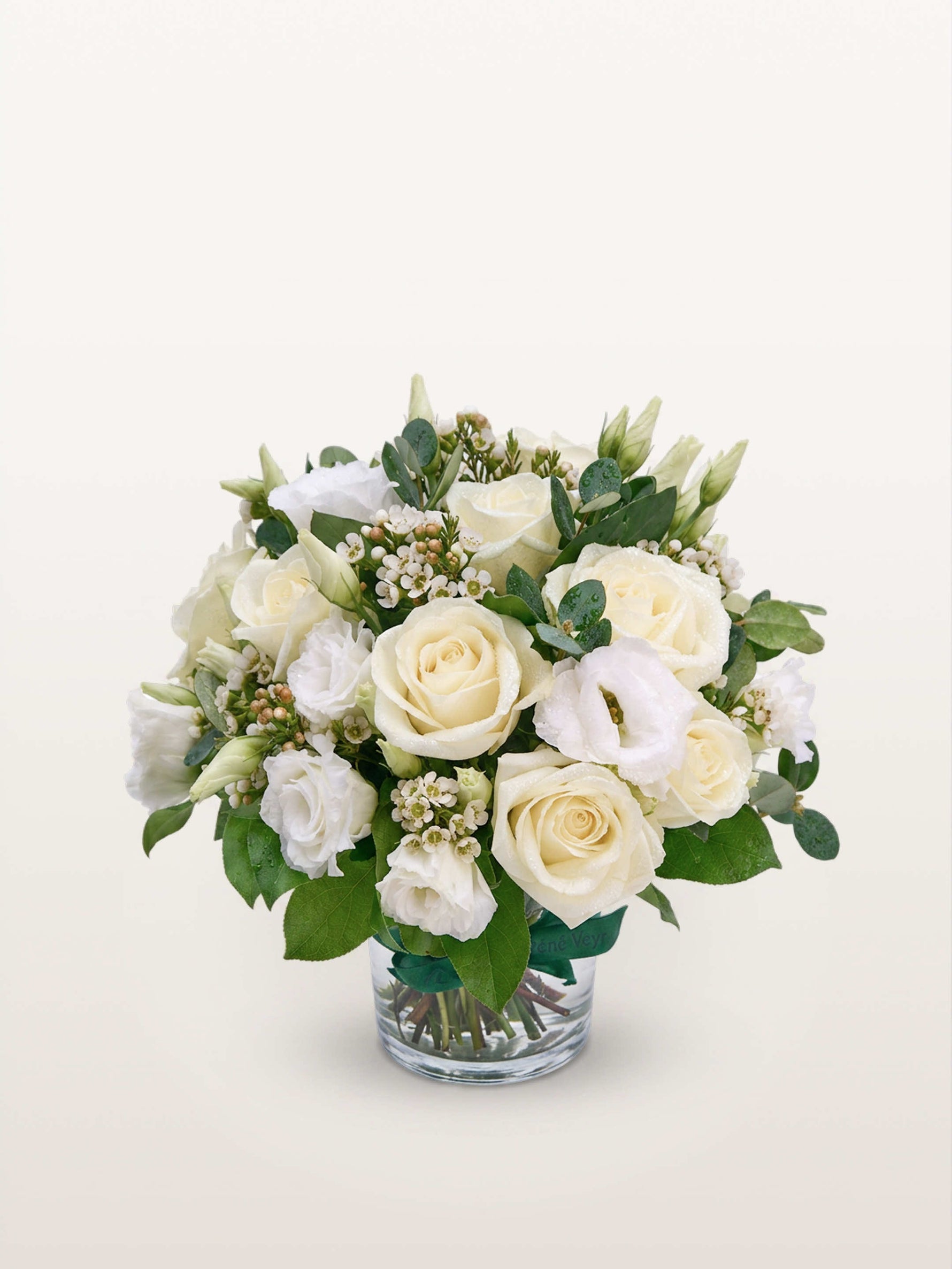 Reine Blanche S, roses ivoire et lisianthus blancs assemblés avec de l'eucalyptus dans un vase en verre