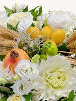 Roses blanches, dahlia crème, citrons jaunes et grenade orangée parmi épis de blé et brins secs