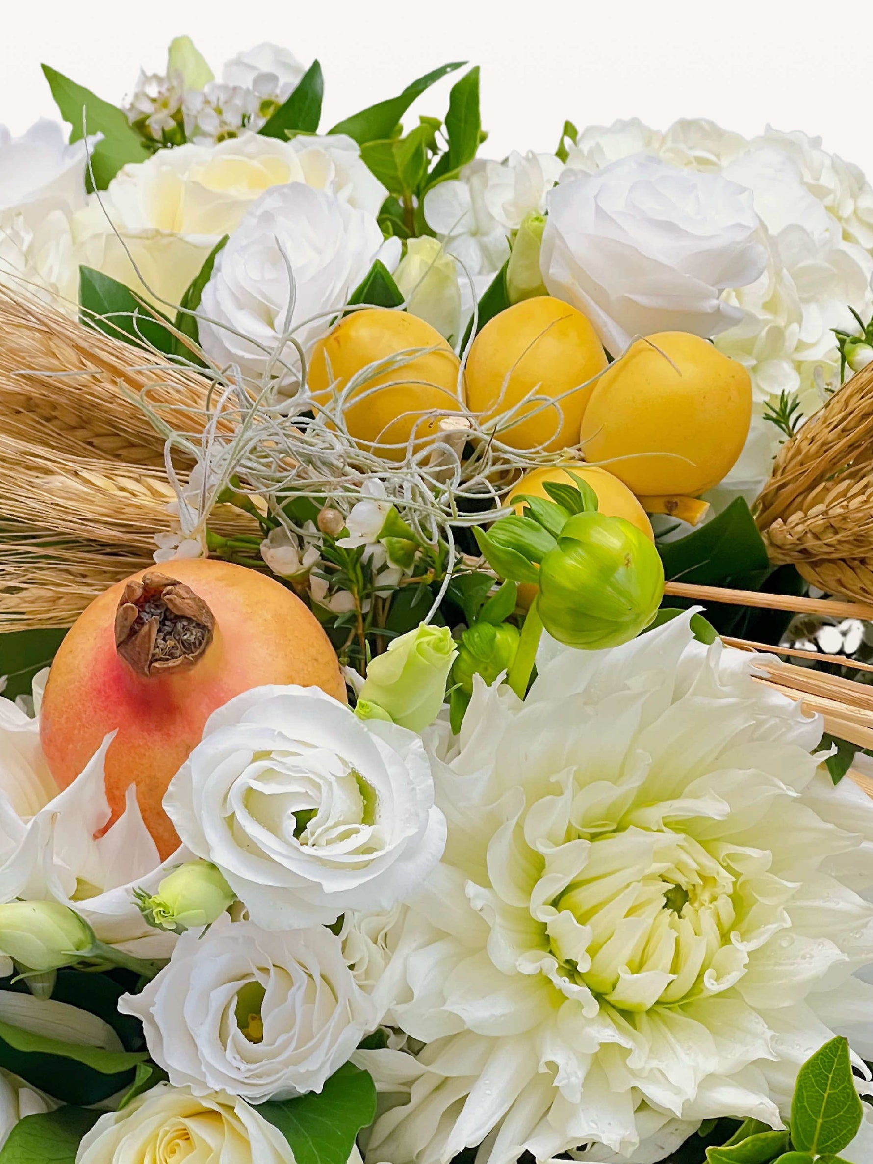 Roses blanches, dahlia crème, citrons jaunes et grenade orangée parmi épis de blé et brins secs