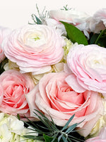 Championnet, roses roses et renoncules blanc-rose entourées de feuillage vert