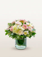 Championnet, roses roses et blanches, renoncules ivoire et hortensias, vase en verre transparent