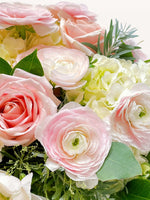 Roses roses, renoncules pâles et hortensias blancs entourés de feuillage vert pour le Championnet