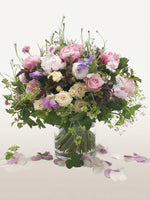 Jardin des Plantes : pivoines roses, roses crème et fleurs mauves dans un vase cylindrique transparent