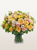 Point du Jour L, roses abricot, œillets roses et lisianthus dans un vase en verre noué de ruban vert