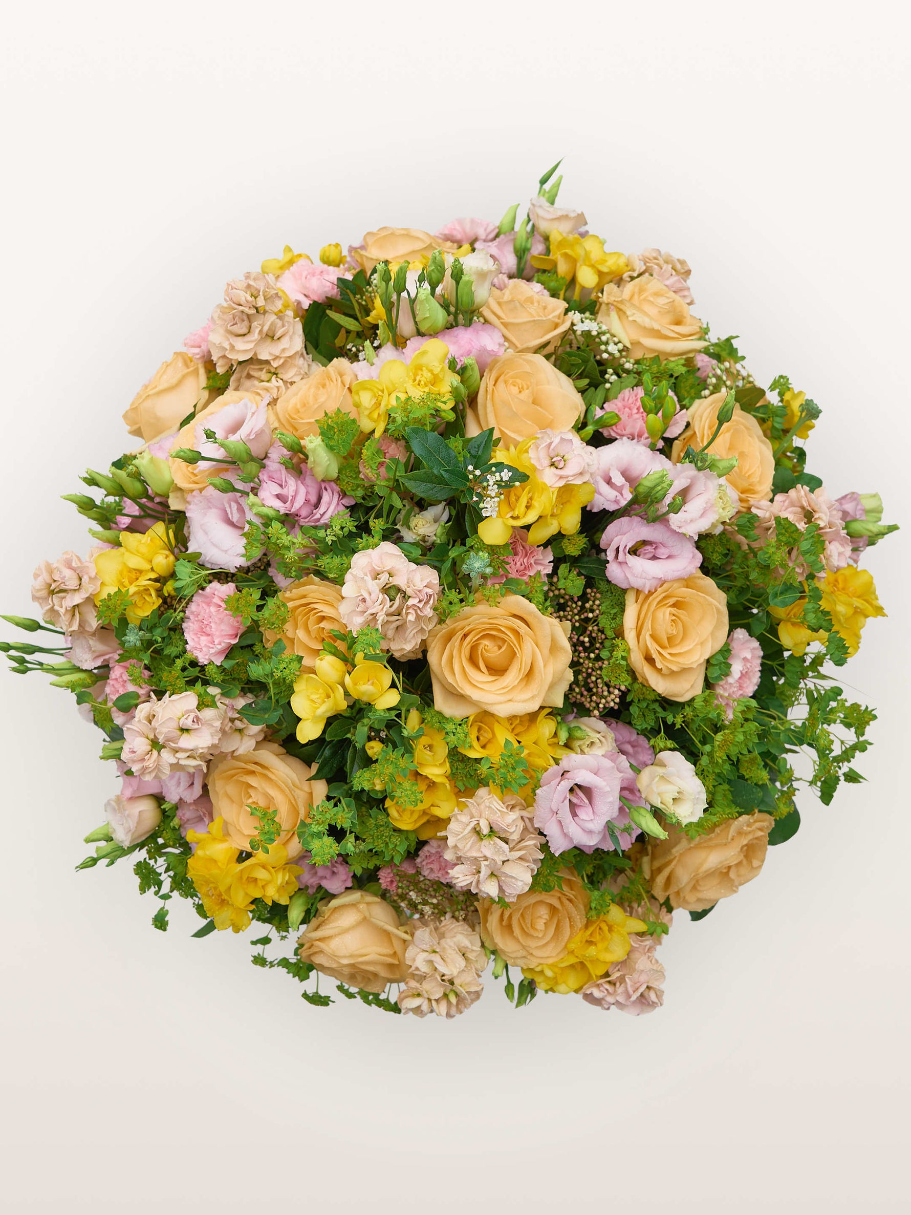 Point du Jour L, roses pêche, lisianthus roses et ivoire, freesias jaunes et verdure formant un bouquet rond