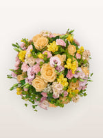 Point du Jour M, roses abricot, lisianthus rose, freesias jaunes et œillets roses en dôme fleuri