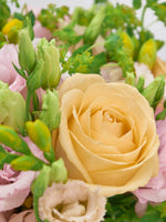 Rose jaune pâle entourée de boutons verts de lisianthus et de roses pâles, Point du Jour S