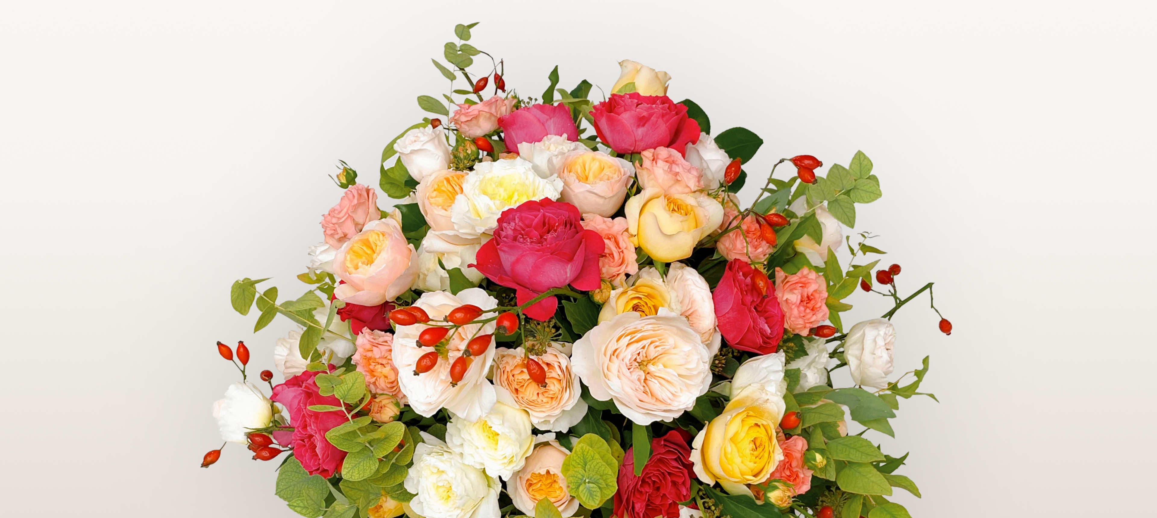 Rue de la Rosière : roses roses, blanches, jaunes et fuchsia mêlées à des baies d'églantier et du feuillage