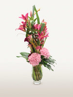 Beaux Arts, lys roses, hortensias roses, callas et feuillages verts dans un vase en verre cylindrique