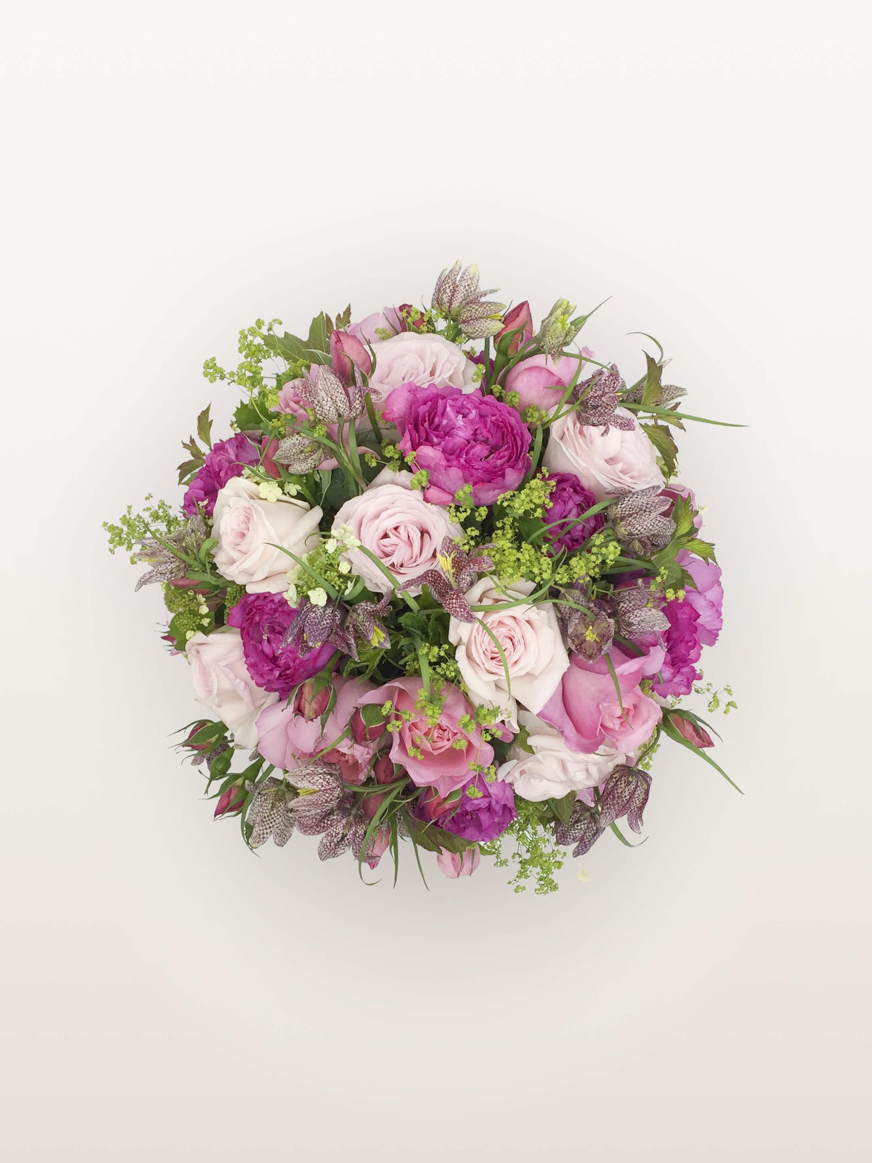 Bouquet rond Parc Monceau de taille M mêlant roses roses et fuchsia, fritillaires pommelées et fleurs de lierre vert tendre