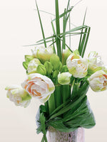 Villa des Nymphéas L présente un bouquet graphique de d'amarylis blanc-vert veinées d'orangé, encerclées de feuilles graphiques et brins verticaux